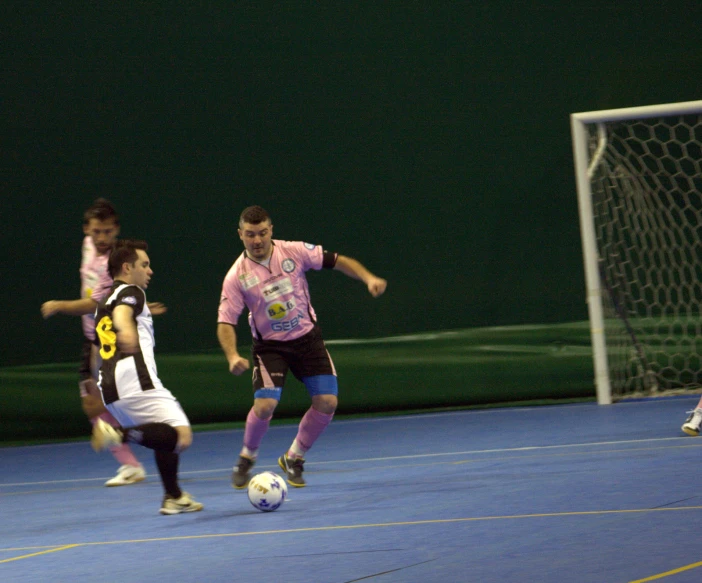 a soccer player dribbles the ball away from a player as they compete