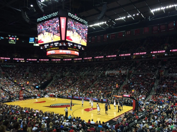 several people at a basketball game in a large stadium