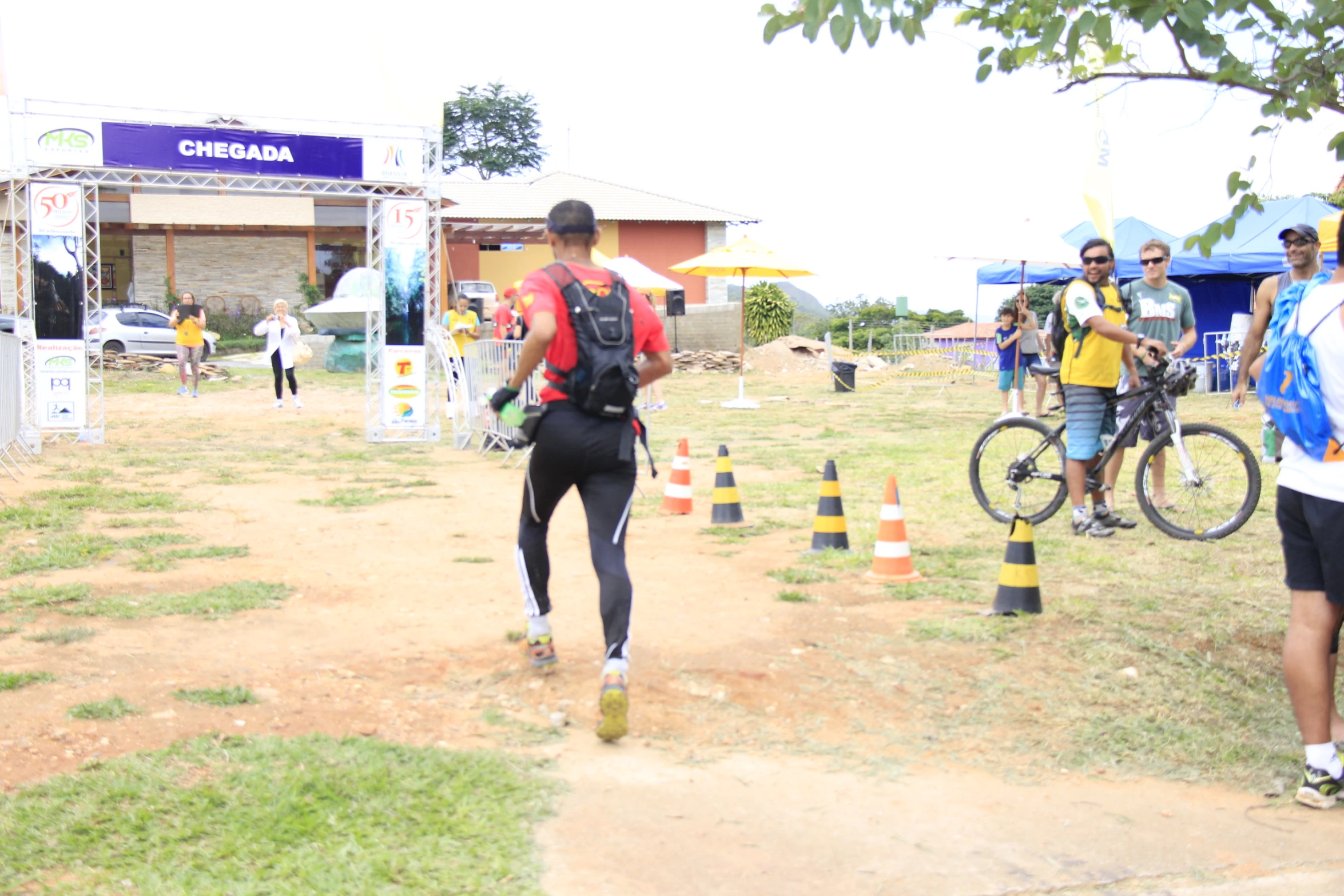 a man that is running in dirt near trees