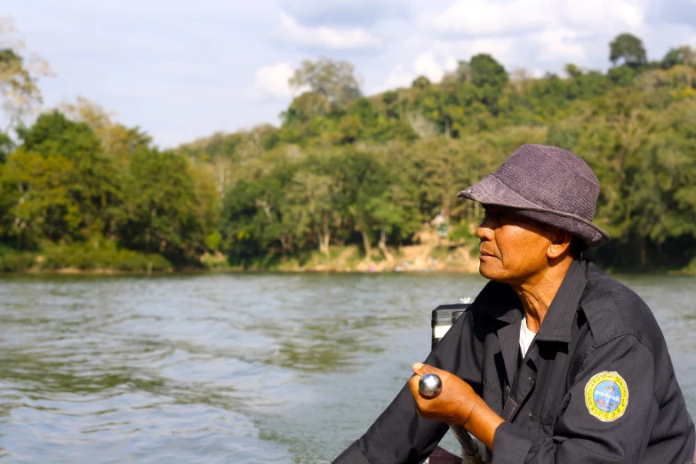 the man is wearing a hat and holding a small object