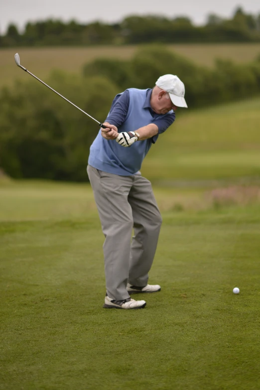 a man swinging his golf club toward a ball