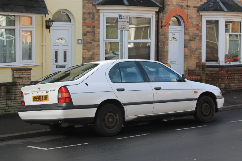 a car is parked on the side of a street near some houses