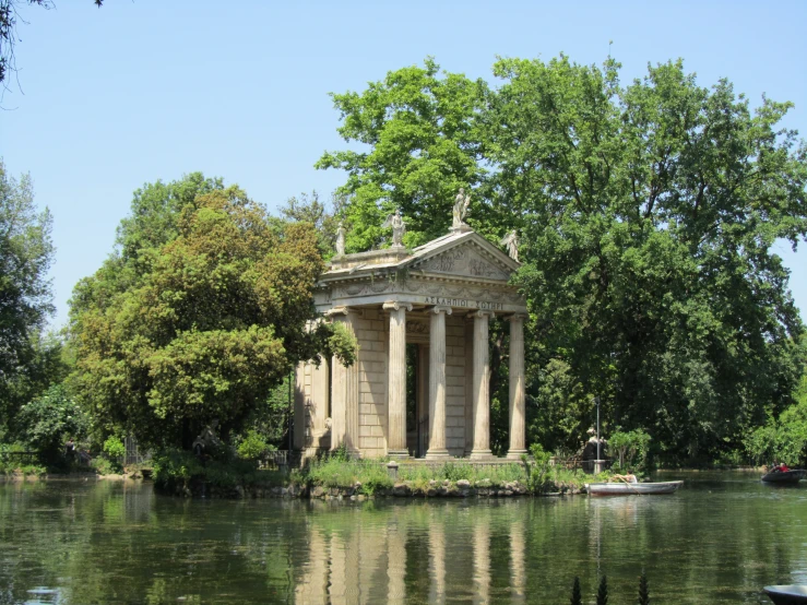 a monument on the edge of the river in the park