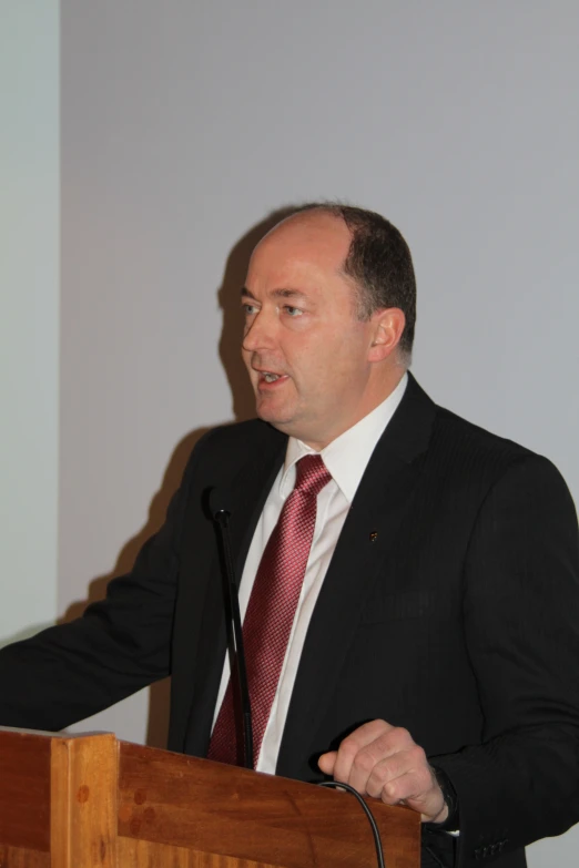 a man is speaking into a microphone at a podium