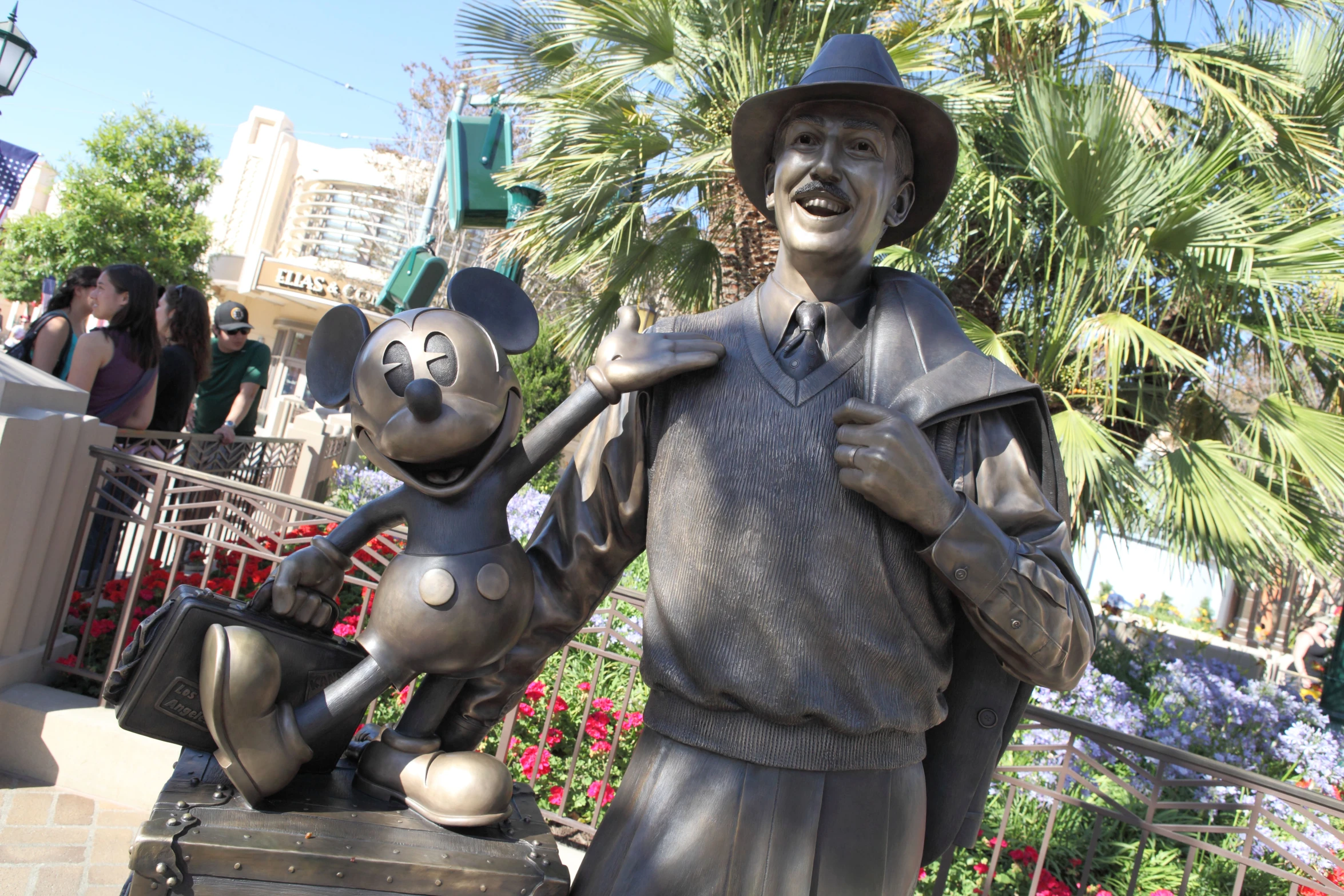 statue of man holding onto mickey mouse with child