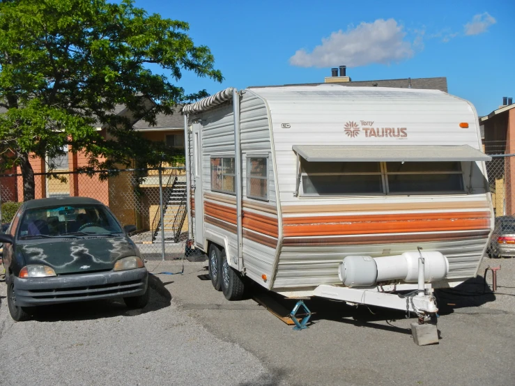 a trailer sits in the parking lot with a parked car nearby