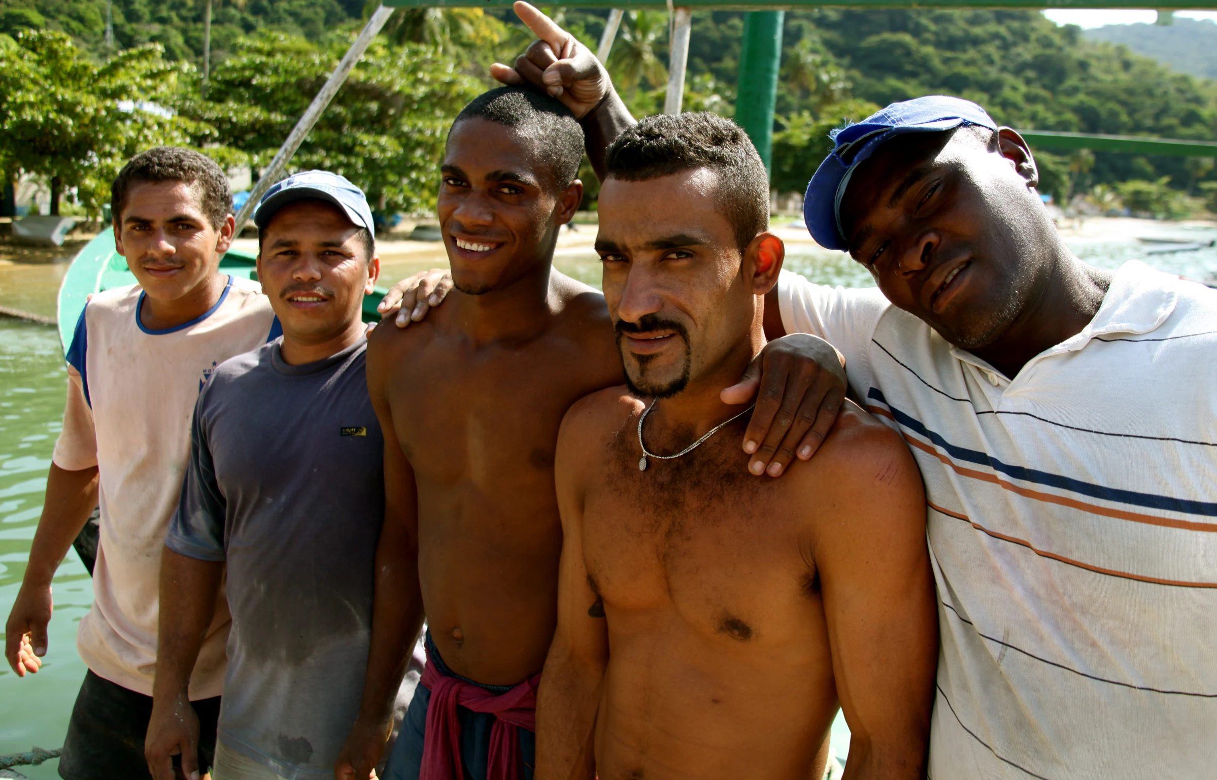 a group of young men posing in front of a body of water