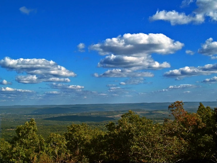 the view from atop a hill with clouds in the distance