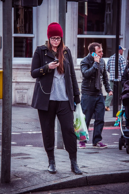 a woman in a red hat and jacket is on her cell phone