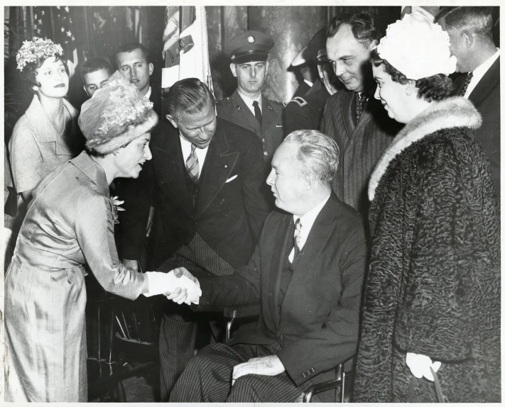 two old men shaking hands next to a crowd