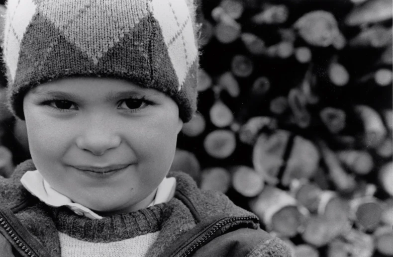 a black and white po of a child wearing a hat