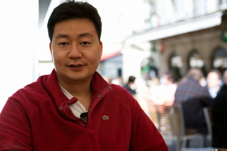 a man is smiling in a restaurant with people eating