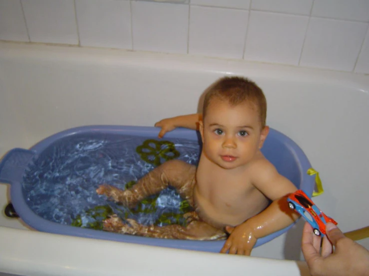 a small boy taking a bath in the tub