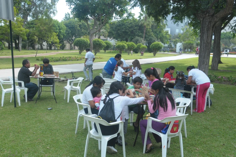 a group of people playing domino at the park
