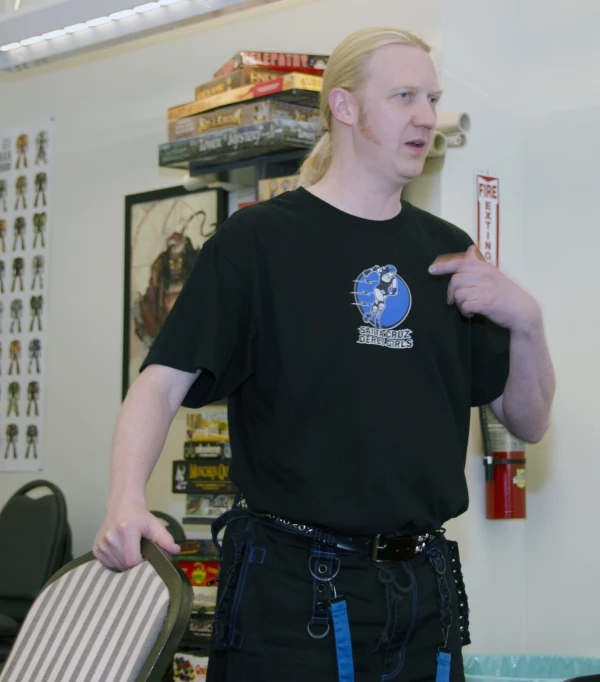 man standing in a room with luggage and a hat