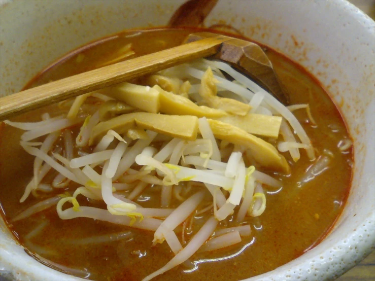 close up of spoons in a bowl of soup