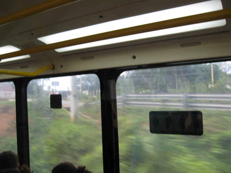 three people in a bus moving with the window open