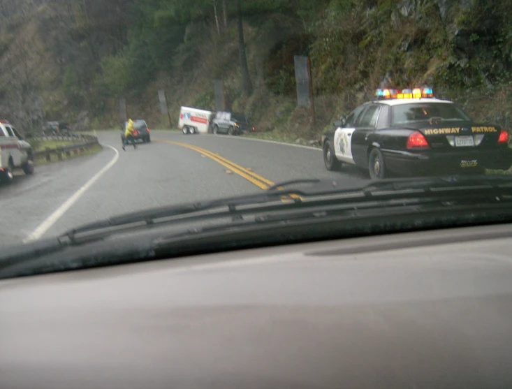 the view of a street police car driving by an accident scene