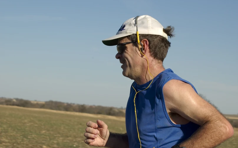 a man with ear buds in the grass