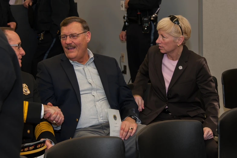 two people in formal wear sitting on chairs