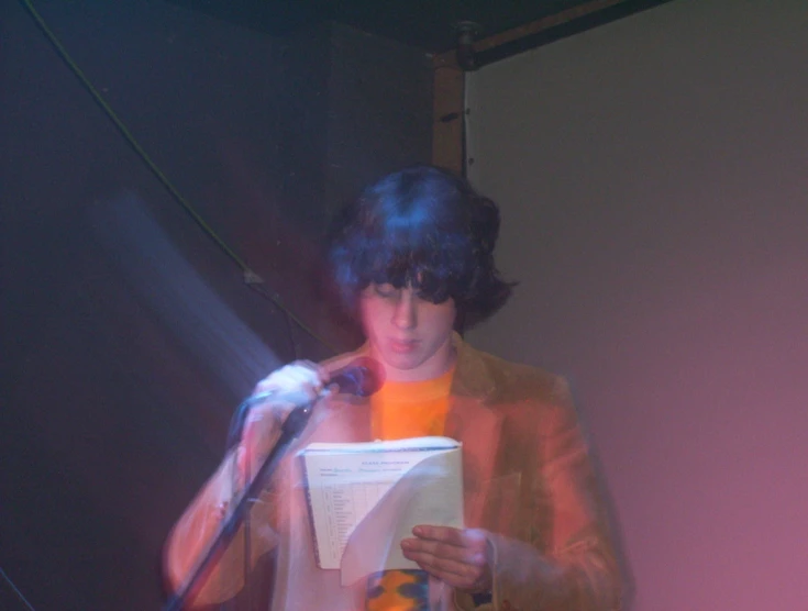 a person holding a microphone and reading