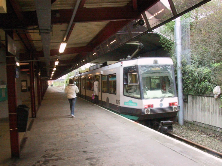 a woman walking toward a train on the tracks