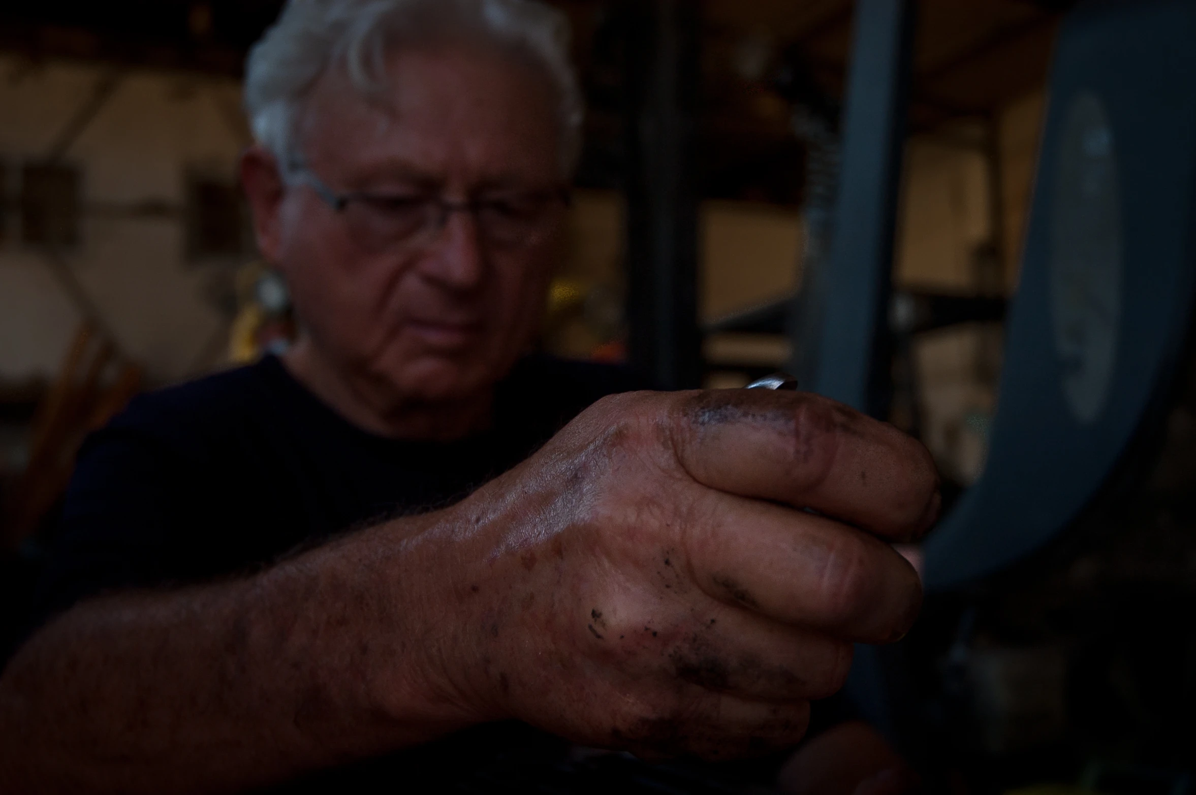 an older man working with soing in his hands