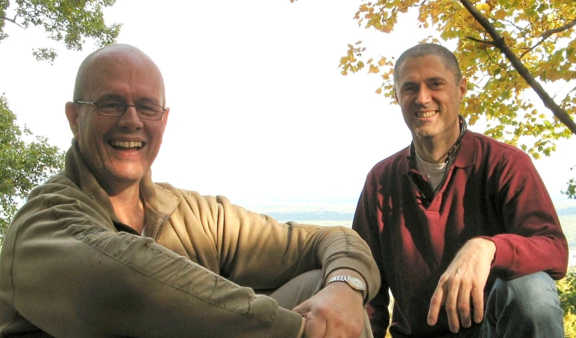 two men posing with their hands folded out in the air