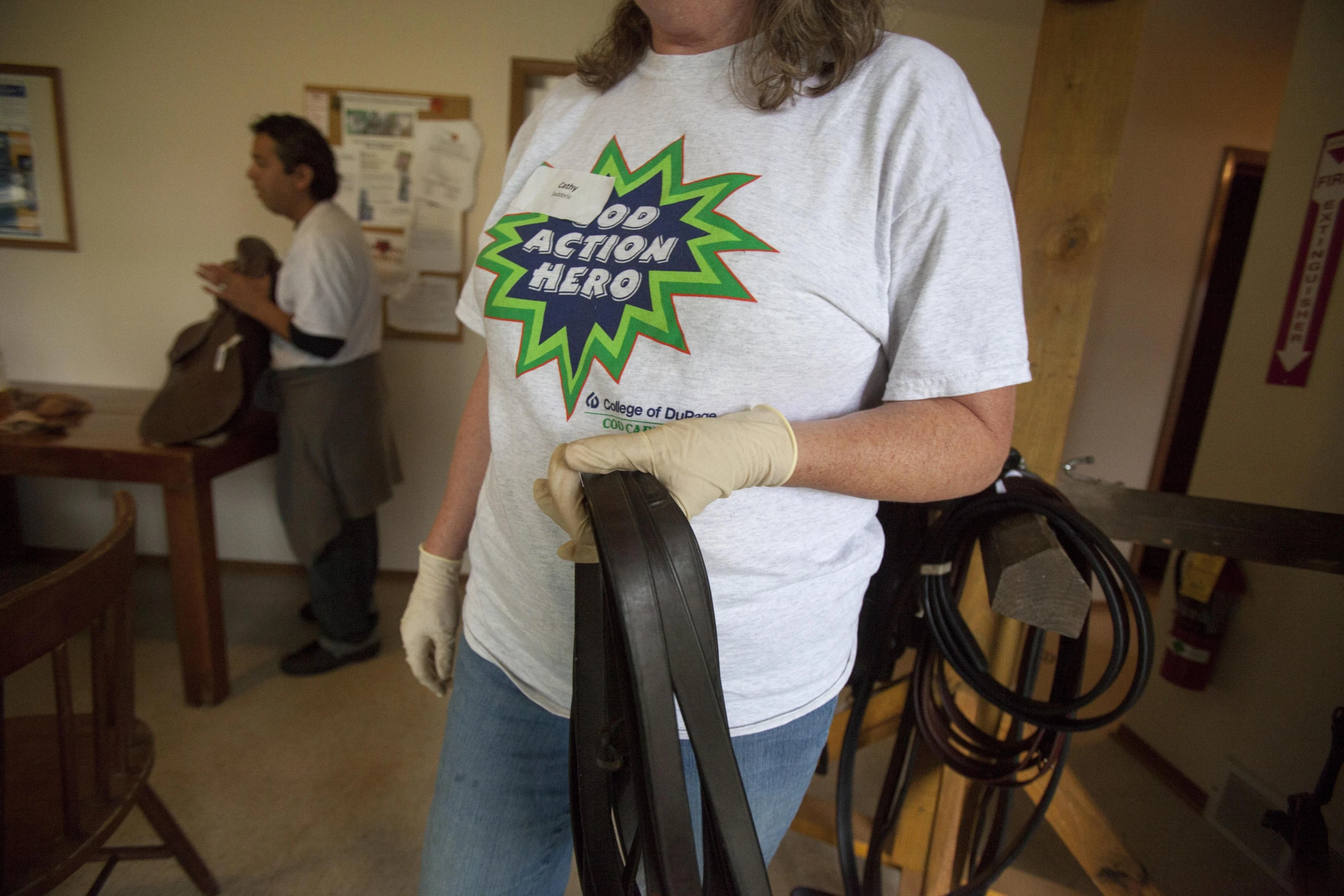 a person in white shirt and gloves holding a metal railing