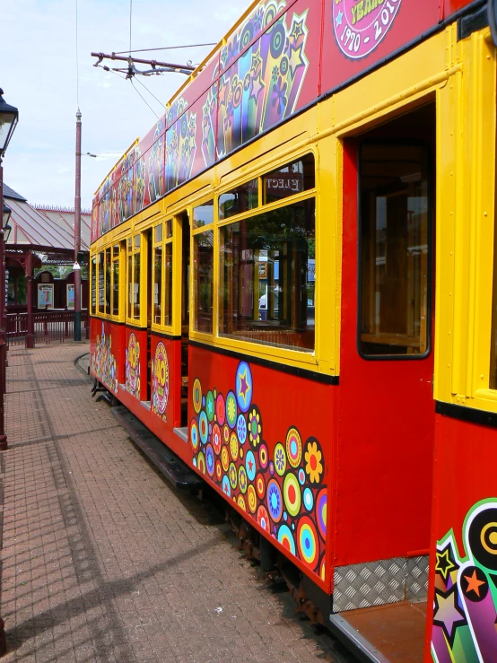 a long red and yellow train with lots of art on it's side