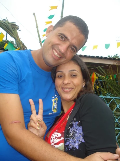two people pose for a po with one holding the peace sign