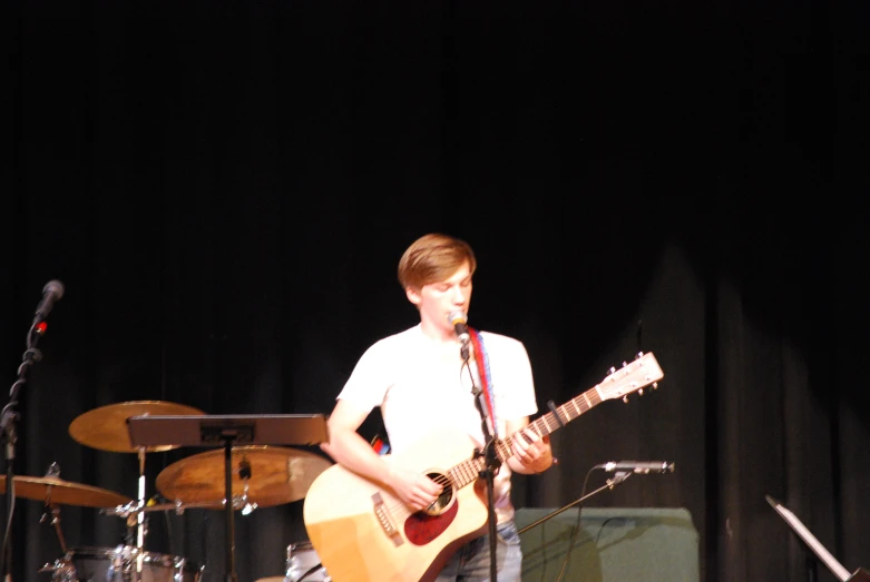 a man that is standing in front of a guitar