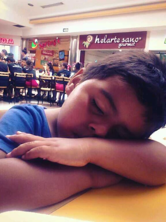 a young child asleep on a table in a restuarant