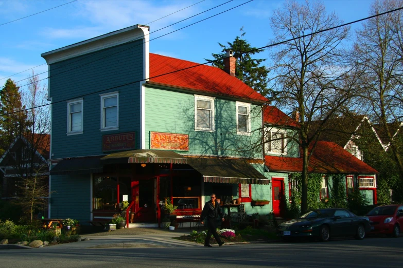 a blue building with red roofs sitting next to a road
