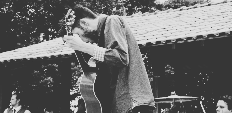 black and white pograph of a man with an acoustic instrument