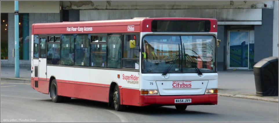 a red and white bus traveling down the road