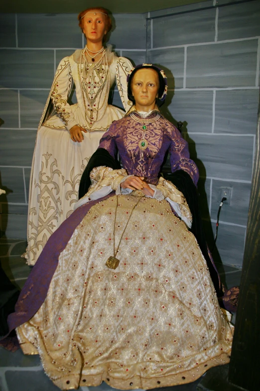 two mannequins wearing period clothing displayed in a museum case