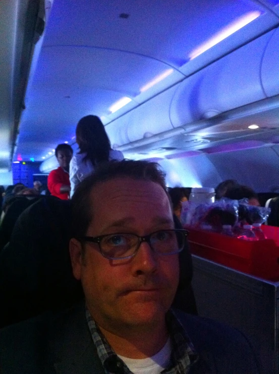 a man sitting in the seat on a plane with passengers