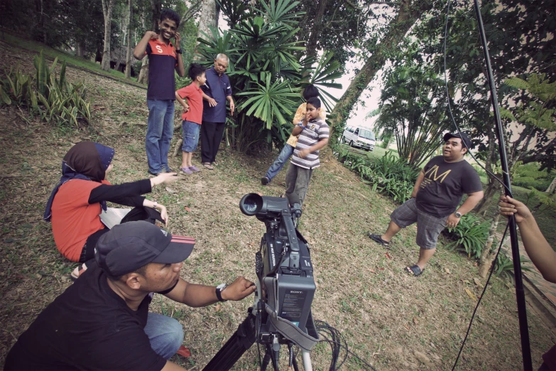 several people gather around a telescope, watching as one of them takes pictures