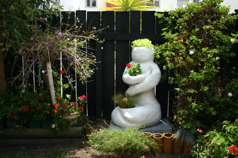 a couple of white statues in a garden