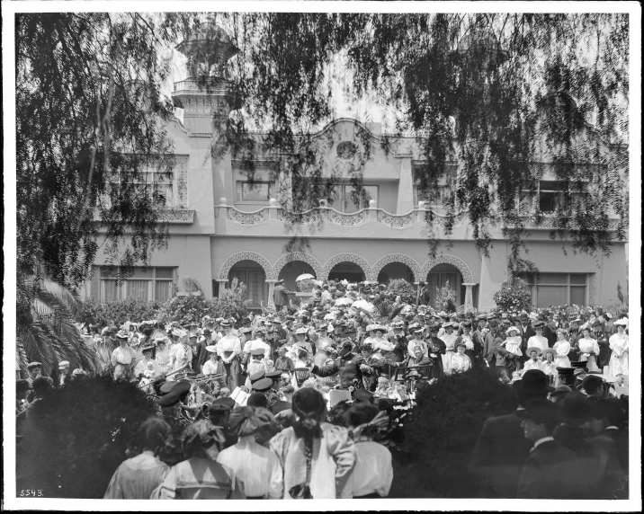 the crowd is all gathered together by the building