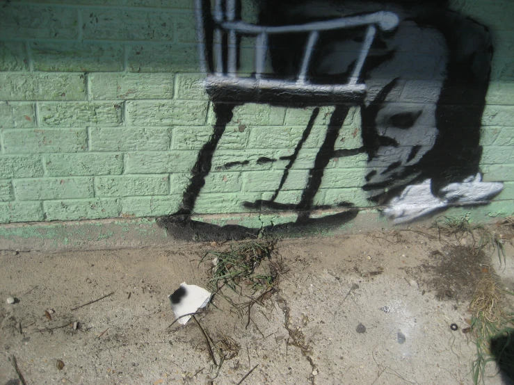 a white object with black and grey graffiti and green wall