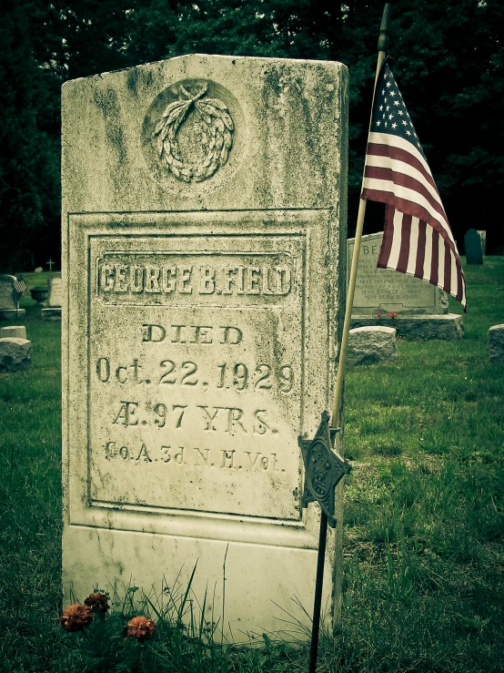 american flag placed in stone in graveyard