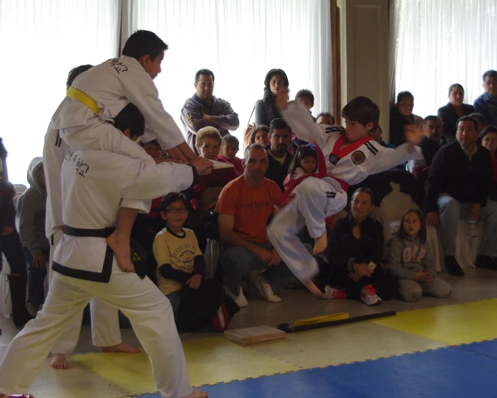 young men practicing karate moves while onlookers watch