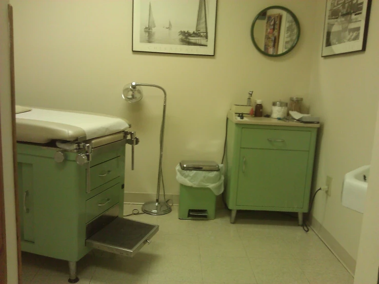 a bathroom that has a green sink and cabinets in it