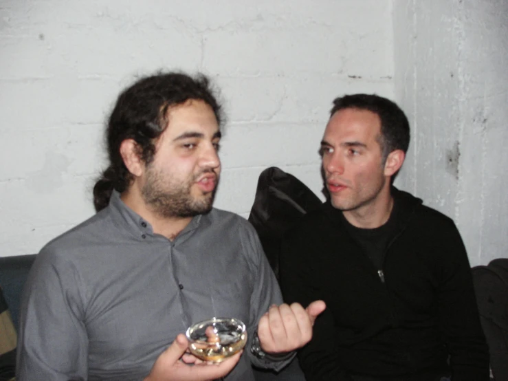 two men are holding bowls of food in their hands