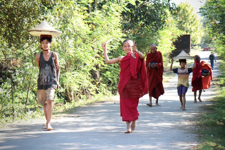 a group of people walk down a street in red robes