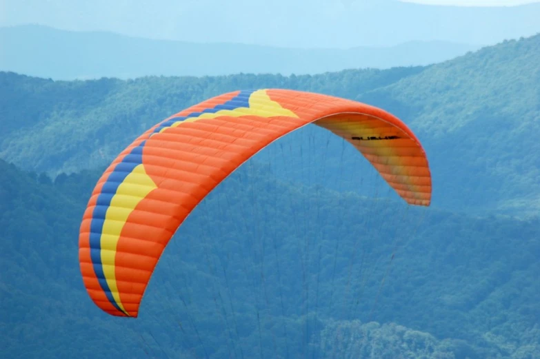 a para glider riding over a mountain range