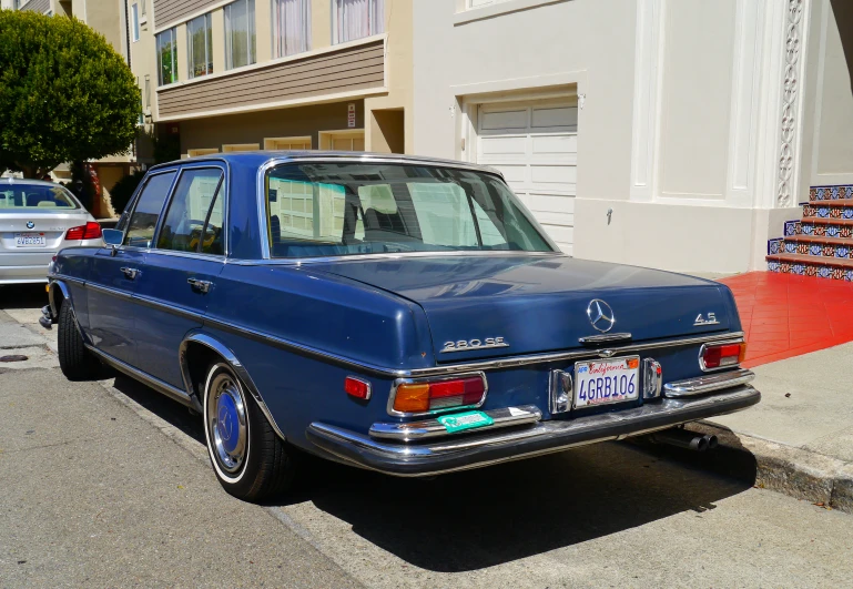 a vintage blue mercedes sitting on the street