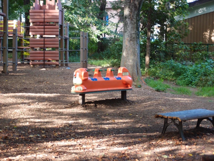 a park bench and swing set in the woods